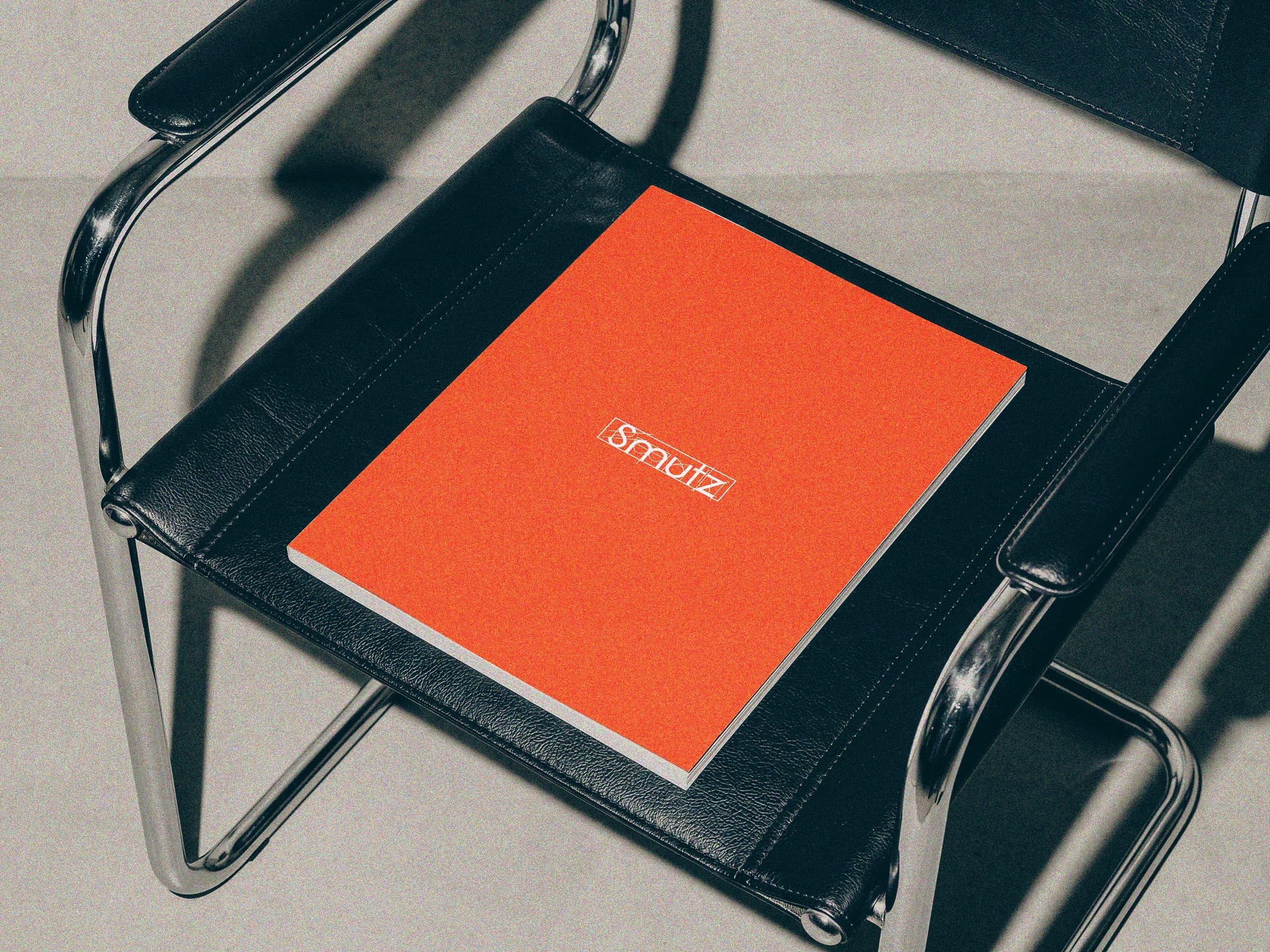Smutz Studios — revista com a identidade da marca sobre uma cadeira